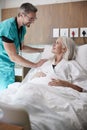 Surgeon Visiting And Talking With Mature Female Patient In Hospital Bed