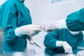 The surgeon was handed a pair of scissors to another doctor. Close-up of surgeons hands holding surgical scissors and passing Royalty Free Stock Photo