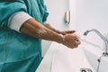 Surgeon washing hands before operating patient in hospital - Medical worker getting ready for fighting against corona virus Royalty Free Stock Photo