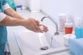 Surgeon washing his hands at hospital cleaning room during Coronavirus outbreak - Focus on right hand Royalty Free Stock Photo