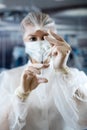 Surgeon woman doctor wearing uniform mask and gloves holding blood at test tube in surgery clinic Royalty Free Stock Photo