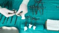 Surgeon working in operating room, hands with gloves holding scissors of suture and torundas, conceptual image