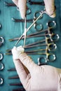 Surgeon working in operating room, hands with gloves holding scissors with torunda, conceptual image Royalty Free Stock Photo