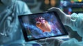 A surgeons hand holding a tablet device using an interactive 3D heart model to explain a procedure to a patients family