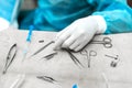Surgeons hand taking scissors, forceps and surgical instruments on table for operation performing work in operation room at Royalty Free Stock Photo
