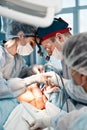 Surgeons men and women in one team during an operation over the operating table, doctors in modern equipment perform an Royalty Free Stock Photo