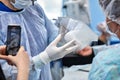 Surgeons during surgery with breast implants in their hands, installation of breast implants, surgery. Plastic surgery Royalty Free Stock Photo