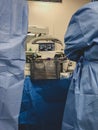 Surgeons using surgical instruments for keyhole surgery, watching the monitor which displays images from inside the patient`s abdo