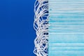 Surgery and medical face masks for coronaviruse on classic blue color background. Close-up view of lot respiratory face