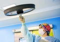 Surgeon adjusts the lamp in operating room