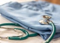 Surgical doctor gown on working table in medical clinic with stethoscope for heart and cardiological diagnostic exam and surgeon