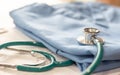 Surgical doctor gown on working table in medical clinic with stethoscope for heart and cardiological diagnostic exam and surgeon`s