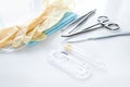 Surgical instruments forceps for closing a wound, curved tweezers, thread with needle, medical mask and rubber gloves on white bac Royalty Free Stock Photo