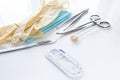 Surgical instruments forceps for closing a wound, curved tweezers, thread with needle, medical mask and rubber gloves on white bac Royalty Free Stock Photo