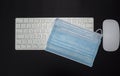 Surgical or medical mask, keyboard for pc and mouse. Office context. Face mask protection against coronavirus, Covid19, pollution Royalty Free Stock Photo