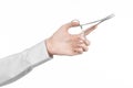 Surgical and Medical theme: doctor's hand in a white lab coat holding a surgical clamp scissors isolated on a white background Royalty Free Stock Photo