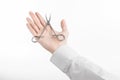 Surgical and Medical theme: doctor's hand in a white lab coat holding a surgical clamp scissors isolated on a white background Royalty Free Stock Photo