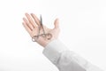 Surgical and Medical theme: doctor's hand in a white lab coat holding a surgical clamp scissors isolated on a white background Royalty Free Stock Photo