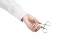 Surgical and Medical theme: doctor's hand in a white lab coat holding a surgical clamp scissors isolated on a white background Royalty Free Stock Photo