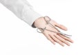 Surgical and Medical theme: doctor's hand in a white lab coat holding a surgical clamp scissors isolated on a white background Royalty Free Stock Photo