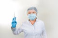 Surgical Nurse in cap and mask in medical clinic. A syringe with medicine is in the hands of a nurse. Close-up portrait. Health Royalty Free Stock Photo