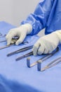 Surgical nurse or surgeon holding medical forceps or instrument inside operating room on blue table. Royalty Free Stock Photo