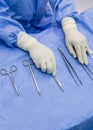 Surgical nurse or surgeon holding medical forceps or instrument inside operating room on blue table. Royalty Free Stock Photo