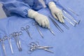 Surgical nurse or surgeon holding medical forceps or instrument inside operating room on blue table Royalty Free Stock Photo