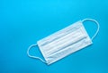 Surgical protective mask on a blue background. Blue medical mask for protection against influenza, coronavirus and other viruses Royalty Free Stock Photo