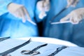 Surgical tools lying on the table while group of surgeons at background operating patient. Steel medical instruments Royalty Free Stock Photo