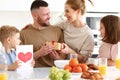 Mom with children congratulating dad with Fathers day while having breakfast in kitchen Royalty Free Stock Photo