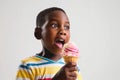 Surprise African Boy Eats Ice Cream On White Background