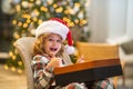 Surprise child opening Christmas magic presents. Little excited kid open with Christmas gift box, celebrating Christmas Royalty Free Stock Photo