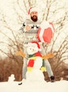 Surprise concept. Winter games. Winter activity. Winter vacation. Man made snowman. Man Santa hat having fun outdoors Royalty Free Stock Photo