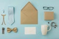 Surprise Father's Day gift. Horizontal view of open envelope, postcard with mustaches, coffee mug, tie, glasses