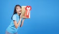 Surprise greeting anniversary birthday or celebration christmas and new year. Cheerful excited young woman holding gold gift box Royalty Free Stock Photo