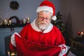 Surprise santa claus opening gift sack in living room Royalty Free Stock Photo