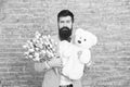 Surprise will melt her heart. Romantic man with flowers and teddy bear. Romantic gift. Macho getting ready romantic date Royalty Free Stock Photo