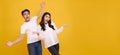 Surprise young Asian couple man and woman happy and amazed on panoramic yellow background