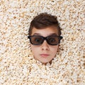 Surprise young boy in stereo glasses looking out of popcorn Royalty Free Stock Photo