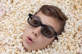 Surprise young boy in stereo glasses looking out of popcorn Royalty Free Stock Photo