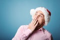 Surprise young cheerful christmas man with santa`s hat over blue Royalty Free Stock Photo