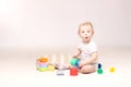 Surprised adorable baby boy sitting on the floor and playing with his toys. Royalty Free Stock Photo