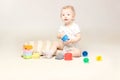 Surprised adorable baby boy sitting on the floor and playing with his toys. Royalty Free Stock Photo