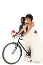 African american bridegroom near cheerful bride with flowers riding bicycle isolated on white Royalty Free Stock Photo