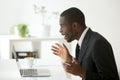 Surprised African American looking at laptop amazed with company Royalty Free Stock Photo