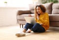 Surprised afro american woman having video call while working or studying online on sofa at home Royalty Free Stock Photo