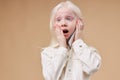 Surprised albino child with phone