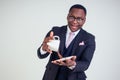 Surprised and amazed handsome afro american business man in a black classic suit and glasses holding a cup with flying Royalty Free Stock Photo