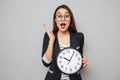 Surprised asian business woman in eyeglasses holding clock Royalty Free Stock Photo